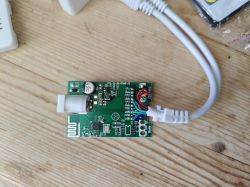 Green PCB with visible chips and electronics, connected to a cable.