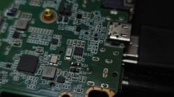 Zbliżenie płytki PCB z portem USB i elementami SMD, widoczne ścieżki i pola lutownicze