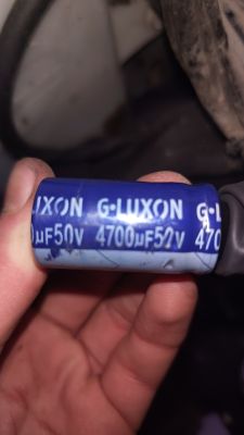 Zbliżenie na niebieski kondensator elektrolityczny 4700µF 50V trzymany w dłoni