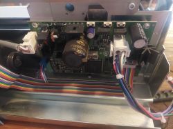Widok zbliżenia na elektronikę wewnątrz urządzenia z widocznymi przewodami i komponentami.