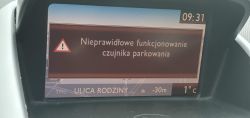 Ekran samochodowy z komunikatem o nieprawidłowym funkcjonowaniu czujnika parkowania.