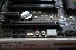 Zbliżenie płyty ASUS z przyciskami PWR_SW i RST_SW oraz wyświetlaczem Q_CODE i świecącą diodą PWR_LED