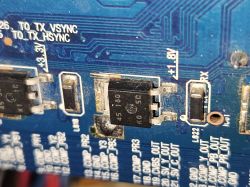 Zbliżenie na płytkę drukowaną z elementami elektronicznymi i oznaczeniem napięcia.