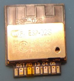 Wi-Fi module ESP-02S with clearly visible pin labels and yellow kapton tape on the ADC pad.