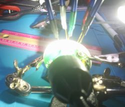 Electronic board with connected wires and measuring tools on a work table.
