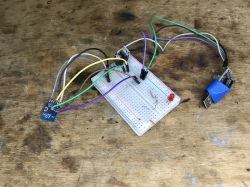 Breadboard with connected wires and modules on a wooden background.
