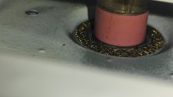 Zbliżenie na ceramiczną końcówkę w otoczeniu metalowej szczotki