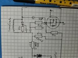 Szkic obwodu elektronicznego na papierze milimetrowym z elementami takimi jak rezystory, transformator i tranzystor.