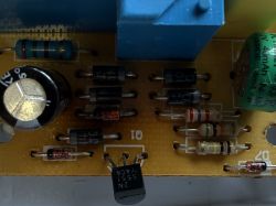 Zbliżenie płytki PCB z przekaźnikiem, diodami, rezystorami i kondensatorami