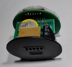 Wnętrze okrągłej obudowy z płytką PCB i gniazdem USB, widok z boku