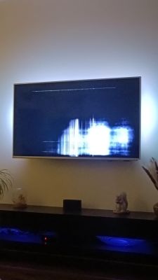 Uszkodzony ekran telewizora Philips z białymi i pionowymi liniami