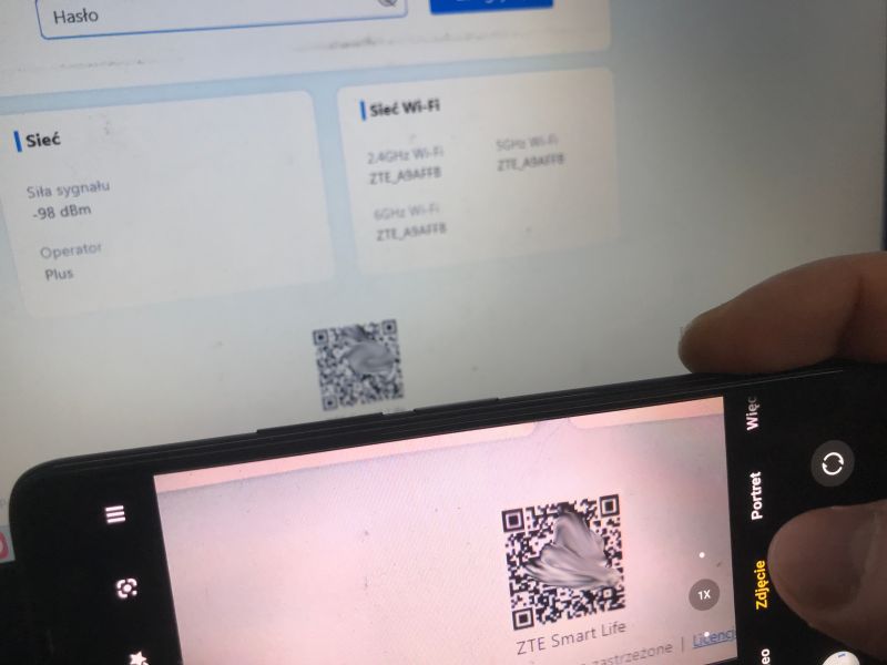 Telefon skanuje kod QR „ZTE Smart Life” z ekranu panelu routera