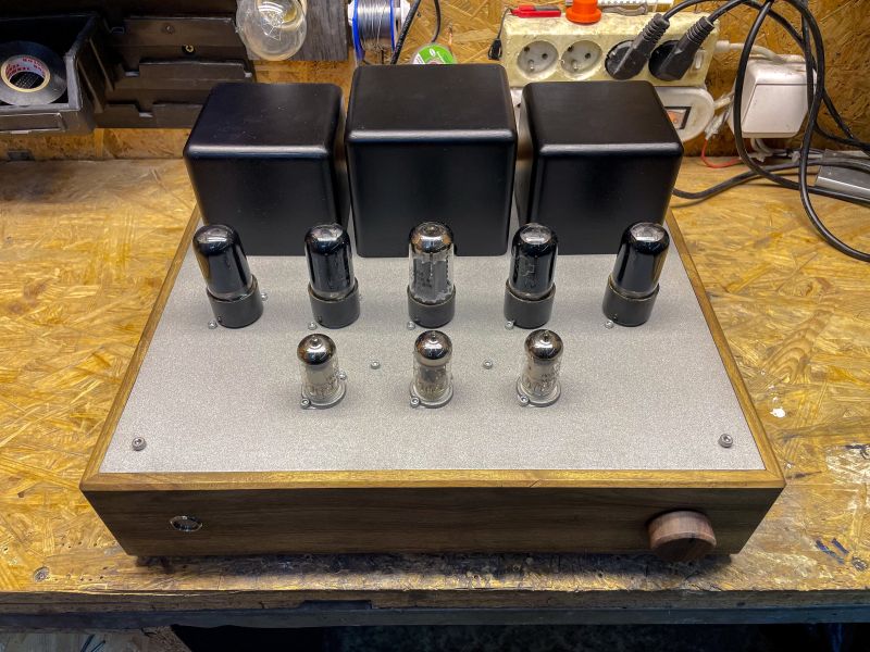 Tube Amplifier on a Workbench Tube amplifier with visible tubes and transformers on a workbench.