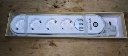 Power Strip with SCHUKO Sockets and USB Ports Power strip with four SCHUKO sockets and three USB ports in a box.