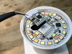 LED board and an adjacent electronic module held by tweezers.