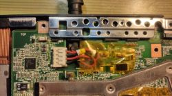 Zbliżenie na płytę główną z podłączonymi kablami i elementami elektronicznymi.
