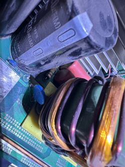 Zdjęcie wnętrza urządzenia elektronicznego z kondensatorem i cewką.