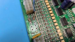 Zbliżenie na fragment płytki PCB z widocznymi śladami przypalenia i brakującymi diodami w obszarze oznaczonym jako X2.