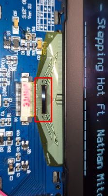 Close-up of a PCB with a display flex cable and a red box highlighting a section near the connector