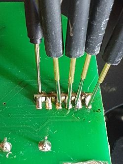 Close-up of a circuit board with several plug-in pins in a connector.