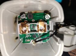 Interior view of an opened electrical plug with a visible circuit board and electronic components.