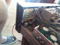 Otwarta obudowa urządzenia elektronicznego z widocznymi kondensatorami i płytką PCB