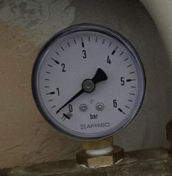 Pressure gauge with a needle indicating 0.9 bar.