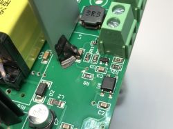 A section of a PCB with electronic components, such as capacitors, resistors, inductor, screw terminal, and an integrated circuit.