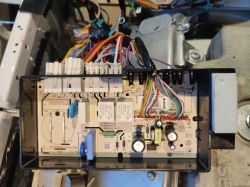 Widok od góry na otwartą obudowę modułu elektrycznego z wieloma kablami i komponentami wewnętrznymi.