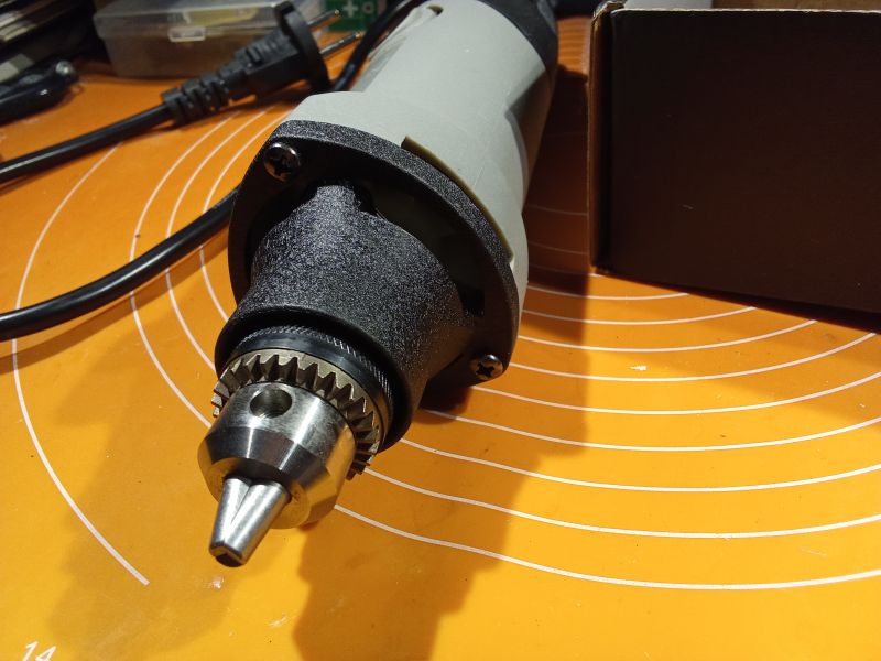 Szlifierka z metalowym futerkiem na pomarańczowym tle.