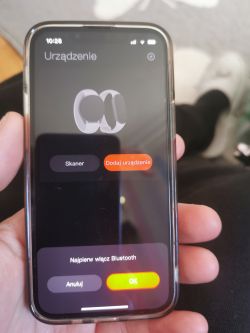 Smartfon z komunikatem o włączeniu Bluetooth podczas parowania urządzenia.