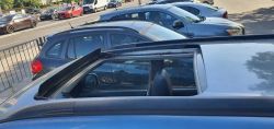 Photo of a parked car with an open sunroof.