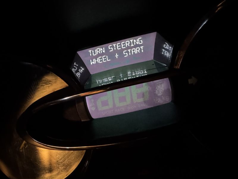 Close-up of a motorcycle digital display showing “TURN STEERING WHEEL + START”.