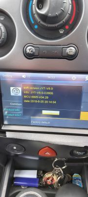 Touchscreen im Auto mit Softwareversionsinformationen und Klimasteuerung.