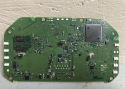 Zdjęcie zielonej płytki drukowanej z zamontowanymi różnymi komponentami elektronicznymi, w tym dużym układem scalonym i kilkoma mniejszymi elementami.