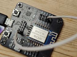 Close-up of a development board with a Hi-Link HLK-M20 Wi‑Fi module and a wire connected to pins