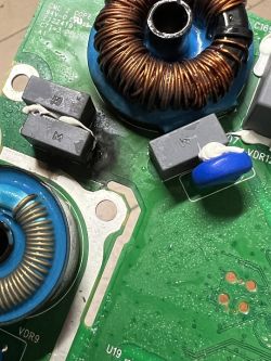 Zbliżenie na płytkę drukowaną z elementami elektronicznymi i cewkami.