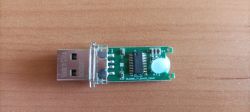 Odsłonięta płytka pendrive’a USB z metalową wtyczką na drewnianym blacie