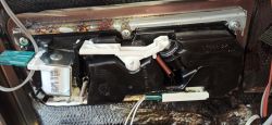 Wnętrze panelu zmywarki z widocznymi elementami elektronicznymi i śladami wilgoci