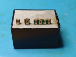 AC-DC power module with cut pins on a blue background