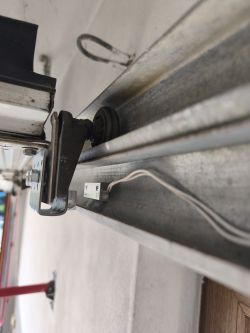 Kontaktron Satel B-3 zamontowany na metalowej prowadnicy bramy kasetowej