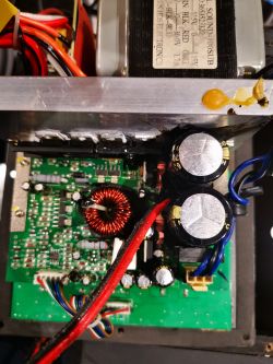 Wnętrze urządzenia elektronicznego z widocznymi kondensatorami i przewodami.