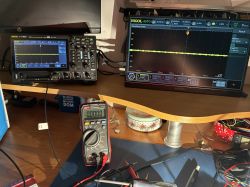 Workbench with Rigol oscilloscope, Arzopa display showing a waveform, and a UNI-T multimeter on the desk