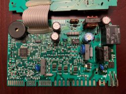 Płyta główna zmywarki z widocznymi elementami elektronicznymi i złączami.