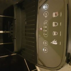 Panel sterowania ekspresu Delonghi z czerwoną ikoną filtra i pulsującą ikoną pary