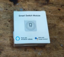 Smart Switch Module Packaging Smart Switch Module packaging on a wooden surface, featuring Amazon Alexa and Google Assistant logos.