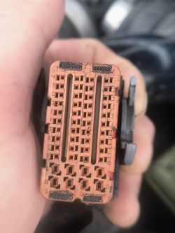 Zbliżenie na kostkę elektryczną z oznaczeniami literowymi i cyfrowymi pinów