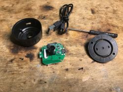 Disassembled camera with electronic components on a wooden table.