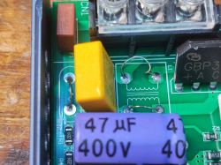 Zbliżenie płytki PCB z kondensatorem 47 µF 400 V, żółtym elementem i mostkiem prostowniczym