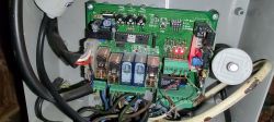 Zbliżenie na płytkę drukowaną centrali z widocznymi komponentami elektronicznymi i okablowaniem.